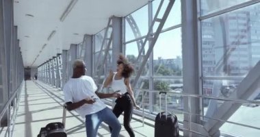 İki Afro-Amerikalı çift, neşeli yeni evli, kıvırcık kız ve siyah adam seyahat dansını kutluyor. Arka planda müzik enstrümanları çalıyor gibi davranıyorlar. Bagaj macerası konsepti.