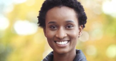 Beyaz dişleriyle gülümseyen Afro Amerikalı kız dışarıda tek başına poz veren kameraya bakıyor. Sokaktaki zenci kadın portresi ahşap arka planda, mutlu kadın yüzü ifadesi.