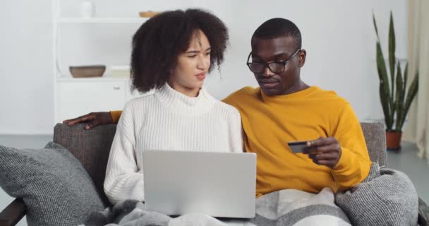 Paar von afroamerikanischen Freunden Mann und Frau online bezahlen in Netzwerk warten auf Transaktion wählen Sie neue Möbel im Haus bestellen im Internet-Shop mit Kreditkarte, Rabatte Verkauf — Stockvideo