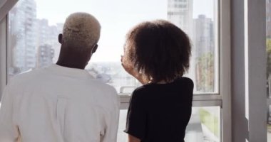 Afro-Amerikan çifti, havaalanı terminalinin penceresinden şehir merkezindeki etnik kızı işaret ederek şehir binasını işaret ediyor ve birlikte iyi yolculuklar diliyoruz.