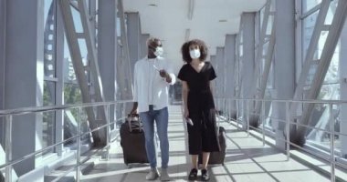 Tıbbi koruyucu maskeler takan Afro-Amerikan çift uçağı kaçırdılar. Geç saatlere kadar saate baktılar. Yurt dışına seyahatleri iptal edildiği için üzüldüler.
