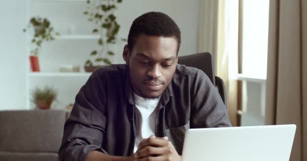 Homem negro afro-americano sério olhando para a tela do laptop com expressão pensativa em seu rosto pondera planos de informações de ideia fantasias, escritor vem com enredo novo, trabalhos estudantis resolve problema — Vídeo de Stock