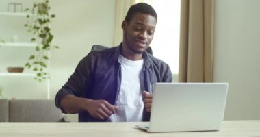 Yakışıklı, gülümseyen afro-amerikan iş adamı serbest çalışan bilgisayar kamerasına konuşan online konferans konuşmalarında video görüşmelerine cevap veren karantina sırasında uzaktan iletişim kavramı.