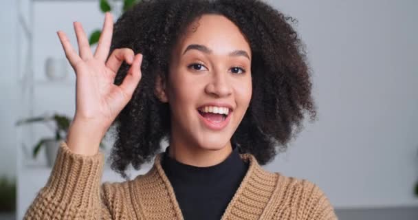 Portrait of ethnic smiling friendly sincere woman showing okay gesture. Afro american girl student rejoices at job done, close-up of female face with perfect makeup, lady showing sign of approval — Stock Video