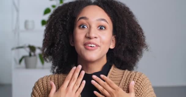 Portret mooi verrast tiener meisje krullend stijlvol schattig afro amerikaanse vrouw close-up vrouw menselijk gezicht scans in camera met wijd open ogen en mond voelt shock genot van informatie hoort — Stockvideo