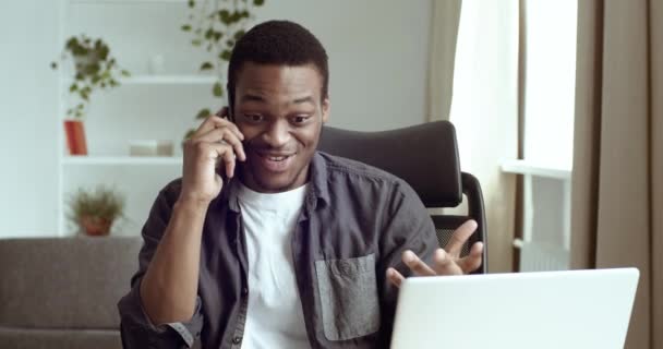 Retrato de hombre de negocios afroamericano feliz vendedor estudiante hablando por teléfono inteligente gana llega a conocer buenas noticias obtiene oportunidad nuevo trabajo dice que sí se siente deleite sentado en la mesa en la oficina o en casa — Vídeos de Stock