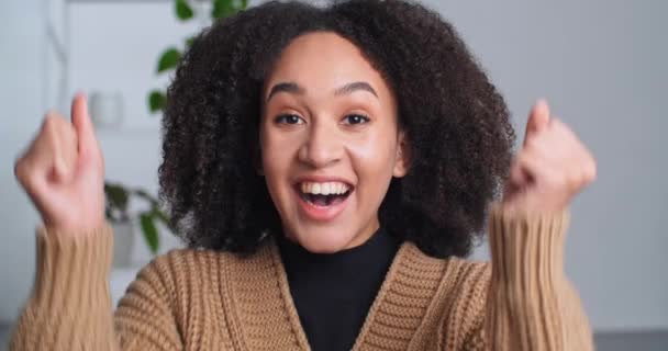 Portrait of afro american successful woman ethnic girl rejoices success victory triumph feels happiness delight screaming moves hands dancing celebrating good news at home, happy female face close up — Stock Video