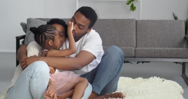 Portrait de famille, couple afro-américain avec fille allonger sur le sol dans la maison neuve propriétaires d'appartements parents novices passer week-end avec petite fille enfant parler discuter, concept de confort chaleur familiale — Video