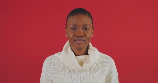 Stay far away. Portert afro american woman puts in front of her palm makes prohibition gesture asks to maintain social distance says no defense personal space fenced stands isolated on red background — Stock Video