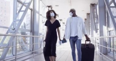 Tanıdık olmayan iki insan, tıbbi maske takıyor. Kız ve erkek, havaalanındaki tren istasyonunda buluşuyor. Afro-Amerikan çift, bavullarını taşıyan karadan uçağa biniyor.