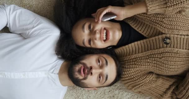 미국 여성과 코카서스 남성이 바닥에 누워 있는 모습, 집에 앉아 있는 다양 한 민족 커플이 휴대폰으로 휴대폰 통화를 하며 웃으며 말하는 모습이 동시에 반복 된다. — 비디오