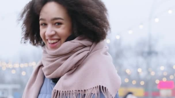 Portrét etnické smíšené rasy tisíciletá dívka okouzlující žena s afro kudrlin tráví čas venku v chladném počasí pózuje svůdně se usmívá na kameru upřímně smích narovnává její vlasy — Stock video