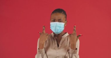 Güvenlik önleyici tıbbi maske takan Afro-Amerikan güzel bir kızın portresi negatif koronovirüs testi için iyi test sonuçları almayı umarak iyi şans diliyor.