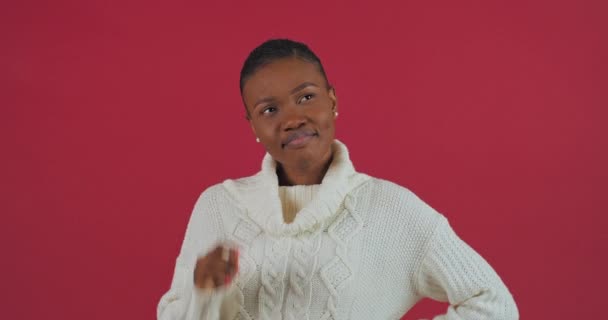 Portret pięknej afro amerykanki młoda mieszana rasa kobieta etniczna modelka nosi biały sweter stoi odizolowany na czerwonym tle studio myśli wymyśla plany na przyszłość uśmiechnięte spojrzenia na aparat — Wideo stockowe