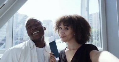 Portre webcam görüntüsü iki kişi gülümsüyor afro saçlı genç adam ve kız birkaç milenyum boyunca el sallayarak bilet ve pasaportları göstererek uçağa binmeden önce fotoğraf çektiriyorlar.
