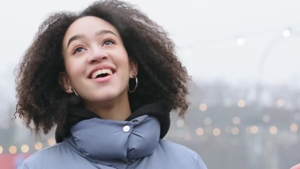 Portré afro amerikai nő göndör haj áll a szabadban télen meleg felsőruházat kilégzés gőz a szájából teszi téli hideg szellő nevet szórakozás a városban alacsony hőmérsékletű éghajlat — Stock videók