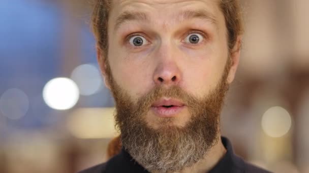 Retrato de hombre caucásico con la barba mirando a la cámara se siente avergonzado arrepentimiento sonrisas de choque atrevido al fracaso cubre su boca con su mano en sorpresa agitando la cabeza condenando negativamente y burlándose — Vídeos de Stock