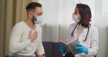 Kadın doktor kağıt defter şikayetleri yazar. Erkek hasta randevu tanısı koyar, erkek hasta ve kadın tıp uzmanı yüz maskesi takar, konsültasyon konsepti...