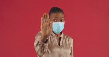 El freni tabelasını kapat. Sembolden uzak dur. Afro-Amerikan kadın steril tıbbi yüz maskesi takıyor. Coronavirüs salgınına karşı mesafeli davranışlar sergiliyor.