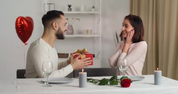 Liebender kaukasischer Mann Ehemann Freund gibt geliebte entzückende Frau Freundin rote Geschenkbox Geschenk für Valentinstag Geburtstag Jahrestag Urlaub Paar Umarmungen als Symbol der Intimität und Zuneigung — Stockvideo