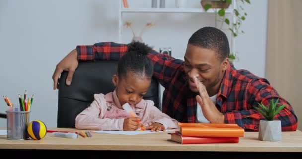 Afro amerikansk fyr kærlig far hjælper lille sød førskole datter til at tegne billede gør lektier understøtter barn giver fem hænder gestus godkendelse til teamwork fremragende resultater, hjemmeundervisning – Stock-video
