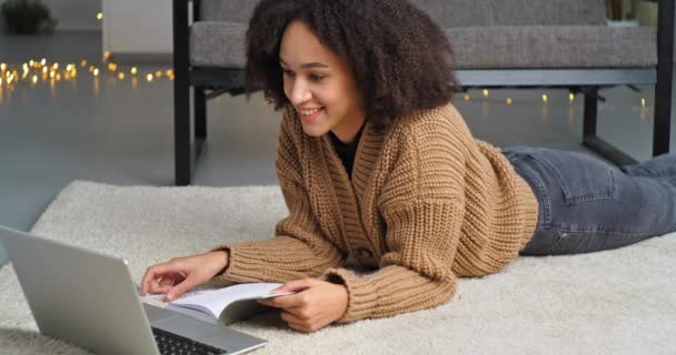 Afrikaans student krullend harig meisje studeren op afstand van huis kijken webinar les over online video chat communiceren met leraar op internet conferentie schrijven in notebook leert taal — Stockvideo