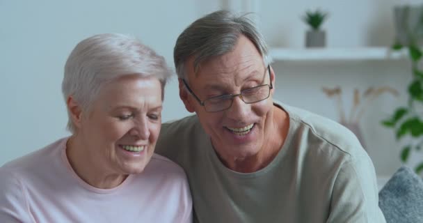Anziani coppia pensionati moderni nonni di famiglia fare videochiamata da casa parlando in webcam comunicare in remoto con i bambini, nipoti o amici attivamente discutendo notizie, concetto di tecnologia — Video Stock