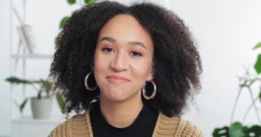 Gülümseyen Afrikalı Afrikalı Amerikalı hippi kız öğrenci saç stili ile webcam 'e bakıyor arkadaşlarıyla sohbet ediyor video görüşmesi yapıyor, sanal sohbet yapıyor, blog vlog kaydediyor, vesikalık portre çekiyor.