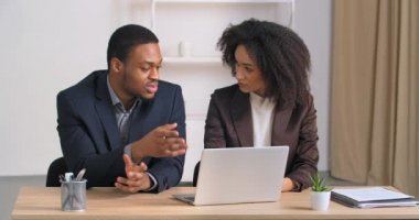 İki iş arkadaşı, erkek ve kadın iş arkadaşları modern ofiste masada oturmuş bilgisayarlara bakıyorlar. Çalışma bütçesi hakkında tartışıyorlar. Erkek sigorta acentesi, mali konularda danışmanlık yapan kızlara bilgisayar kullanarak yardım ediyor.