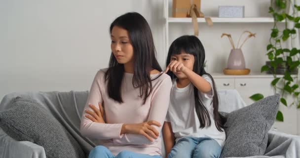 Азіатська жінка ображена матір відчуває смуток і стрес через непорозуміння дитини турбується про генетичну різницю маленька дочка, яка гладить мамині втіхи, заспокоює вибачення за погану поведінку. — стокове відео