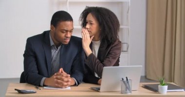 Ofis masasında oturan iki Afro-Amerikalı iş kadını, iş adamına kötü haber müdürü hakkında kötü şeyler fısıldıyor.