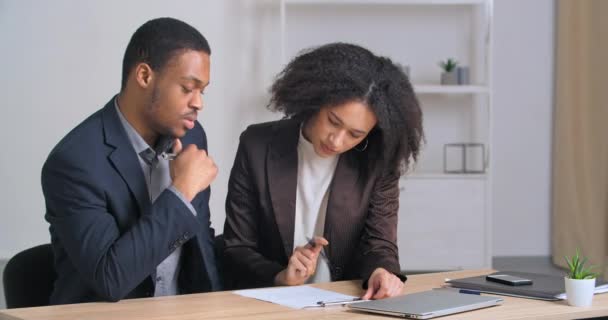 集中アフロアメリカの男性セールスマン保険ブローカーマネージャーは、成功した少数民族の女性の顧客に助言不動産のサイン銀行ローンの雇用契約を購入することに同意表に座って — ストック動画