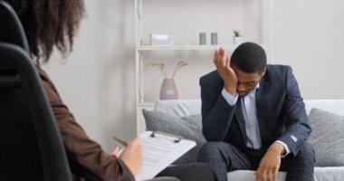 Afro-Amerikalı üzgün iş adamları boşanma sorunlarından endişe ediyorlar. Ellerini tutarak strese giriyorlar. Doktor kadın psikoloğa haftalık psikiyatri seansı için yardıma ihtiyaçları olduğunu söylüyorlar.