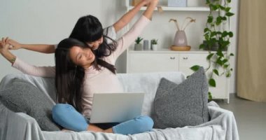 Dizüstü bilgisayarı olan mutlu bir Asyalı aile koltukta oturuyor. Genç Koreli anne, küçük komik bir kız çocuğuyla sırtında küçük bir kız çocuğu taşıyor, uçakla uçuyormuş gibi yapıyor.