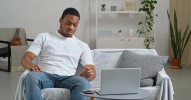 Afro-Amerikan yorgun iş adamı serbest çalışan etnik öğrenci çalışırken kanepede oturdu ve telefon görüşmesinden uyandı. Projenin teslimatını hatırlatıyordu. Dizüstü bilgisayara bakışı endişeli bir utanç hissi veriyor.