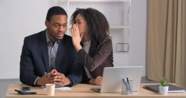 Afro-Amerikalı iş adamları ofiste oturan kötü kadın kulağına fısıldıyor gizli bilgileri paylaşıyorlar sahte dedikodular gülüyorlar adam cep telefonundan şok edici aramalar geldiğine inanıyor