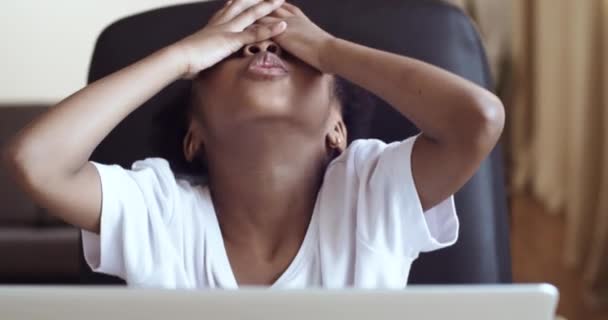 Close-up pouco triste misto raça afro-americana menina criança sentada na frente do laptop sofre de dificuldades de aprendizagem lê más notícias de mãos dadas cabeça de dor sente estresse pressão problema conceito — Vídeo de Stock