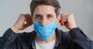 Yüzüne nasıl tıbbi maske takılacağını gösteren beyaz bir gencin portresi ağıza solunum cihazı takıyor, parmağını sallıyor ve burun kapatmak yok diyor. Baş parmaklar yukarı, hijyen kuralları.