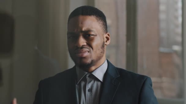 Portrait of unhappy ethnic business man afro american worker standing in office against window background, puts his palms in front of him making prohibiting refusal gesture, expressing disgust denial — Stock Video