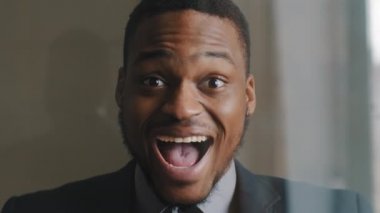 Hevesli, koyu renk saçlı erkek yüzü, takım elbiseli Afro-Amerikan iş adamı portresi şok edici haykırışlar ve sevinç çığlıkları.