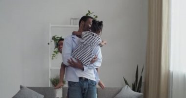 Bakıcı baba, sevgili kızını kollarında tutarken anne, kocasının arkasında saklanan çocuğundan farklı taraflarda kaçıyor. Bebek annesini yakalıyor, Afro-Amerikan ailesi evde oyun oynuyor.