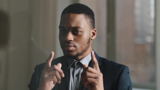 Retrato de negro afro-americano bem sucedido homem de negócios profissional veste terno formal em pé posando no escritório da empresa olhando com expressão séria apontando dedos para a direção da câmera, close-up — Vídeo de Stock