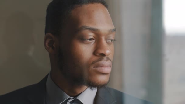 Ritratto di serio concentrato pensoso uomo d'affari dalla pelle scura investitore afro-americano guardando fuori dalla finestra in carica, prendendo decisione ponderando proposta, si gira verso onde della fotocamera annuisce la testa in accordo — Video Stock