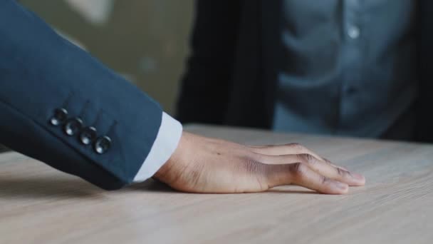 Gros plan groupe multinational de trois personnes empiler les mains mettre les paumes ensemble sur bureau table en bois bureau, unis différents employés multiethniques hommes d'affaires fait geste de travail d'équipe, concept de soutien — Video