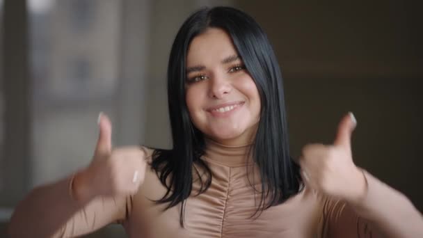 Close-up satisfied female face, portrait mexican spanish brazilian girl millennial model plus size woman posing indoors against window background showing thumbs up, approval gesture, agreement symbol — Αρχείο Βίντεο
