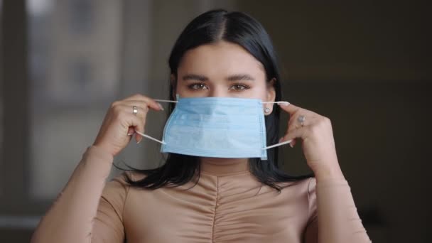 Portrait millennial caucasian brazilian spanish woman mexican ethnic plus size girl puts on medical protective mask on her face wears respirator protecting health from virus infection during pandemic — Stock video