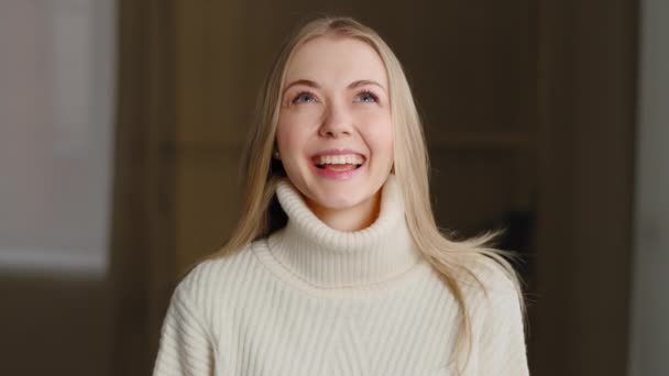 Retrato de feliz linda menina millennial loira em pé dentro de casa olhando para a câmera com dentes brancos saudáveis sorriso. Close-up bem sucedido extático mulher caucasiana regozijo fecha os olhos no prazer — Vídeo de Stock