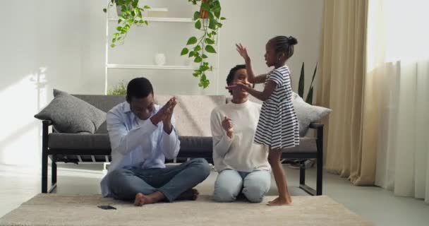 Aktif küçük kız çocuğu, anne ve babasının izleyicilerine şarkı söyler. Elleriyle gösteri hareketlerini izlerler. Aileleri alkışlamalarını isterler. — Stok video