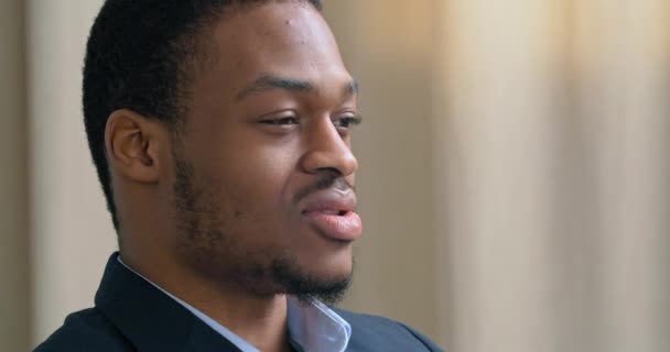 Side view close-up concentrated serious human male face, portrait of Afro American business man in suit sits in profile in office talks about problems to prichologist or advises client negotiating — Stock Video