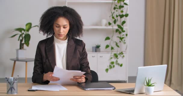 비지니스 여성 매니저 사장은 현대 사무실에서 테이블에 앉아 있는 미국인 여자 사업가 다 성공적 인 회사에서 예산서를 보면 예산서가 진행 보고서를 준비하고, 서류 작업 컨셉을 준비하는 문서처럼 보인다. — 비디오